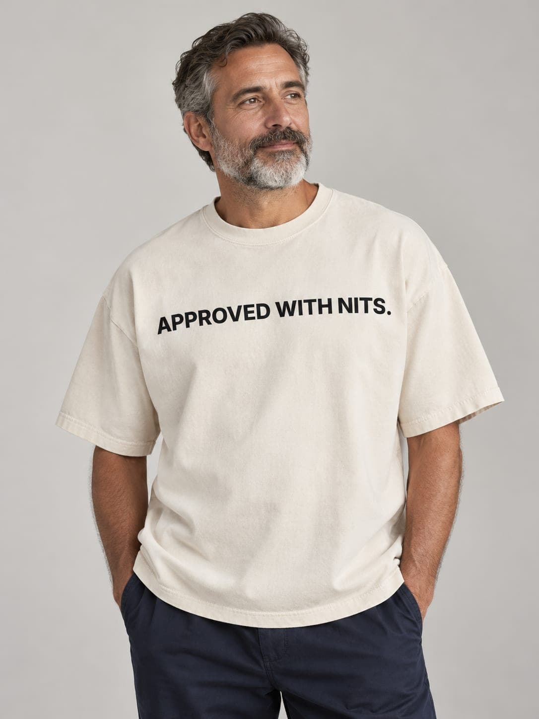 APPROVED WITH NITS Tee in Faded Bone, worn by a model: APPROVED WITH NITS. printed center chest. AI-generated mockup.