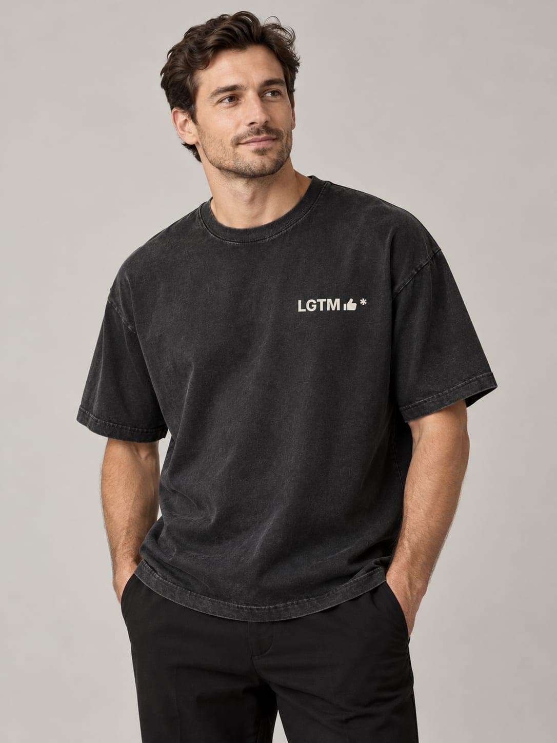 LGTM Tee in Faded Black, worn by a model: LGTM thumbs-up* printed left chest. AI-generated mockup.
