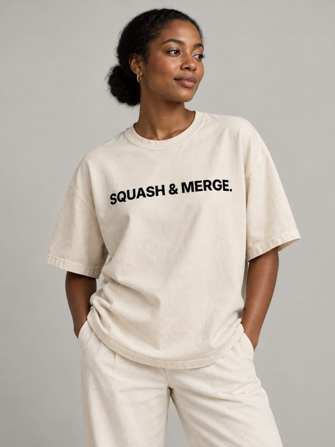 SQUASH & MERGE Tee in Faded Bone, worn by a model: SQUASH & MERGE. printed center chest. AI-generated mockup.